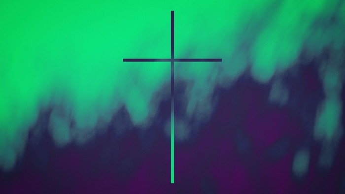 A black cross centered on a blurred, colorful background.