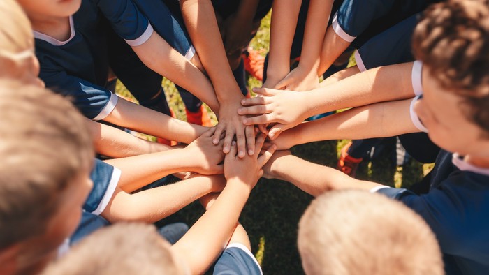 Eine Gruppe von Kindern steht im Kreis und hält sich an den Händen.