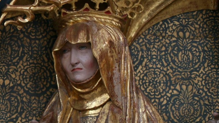 Guldklædt statue af en kvinde.