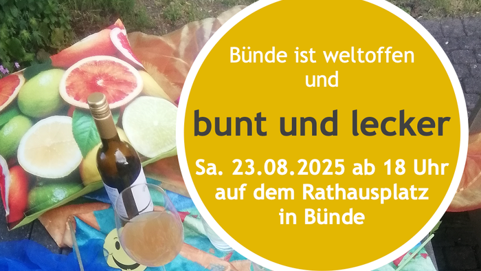 Bunter Picknicktisch mit Obst, Getränkeflasche und Einladungskarte für ein Treffen am 23.08.2025 um 18 Uhr auf dem Rathausplatz in Bünde
