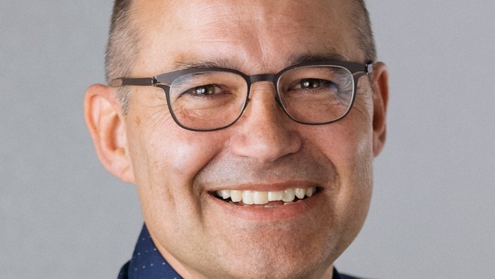 Pfarrer Marcus Tyburski hat den Text für die Homepage des Kirchenkreises geschrieben. Er trägt sein dunkles Haar kurz, hat eine Brille und lächelt auf dem Bild.