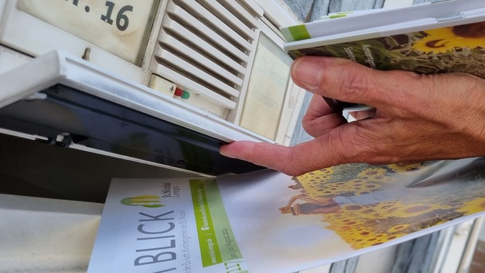 Person steckt Brief in den Briefkasten Nr. 16