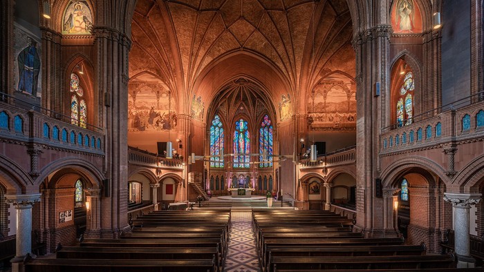 Großartiger Kircheninneraum mit hohen Bögen und bunten Glasfenstern