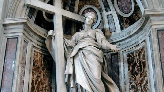 Die Statue einer Frau mit Kreuz in einem prächtigen Gebäude.