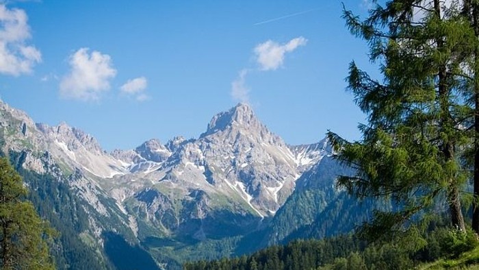 Berglandschaft mit schneebedeckten Gipfeln und grünem Tal