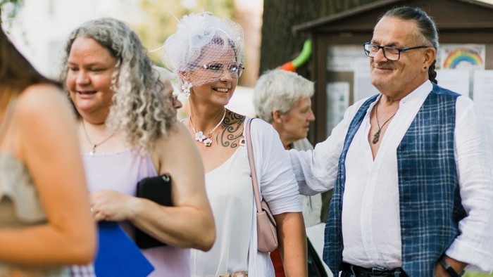 Das Segenshochzeitspaar Patrycja und Hans-Jörg Sprung (1. und 3. v.r.) beim Berliner Hochzeitssommer 2025 neben der Dorfkirche Lübars 