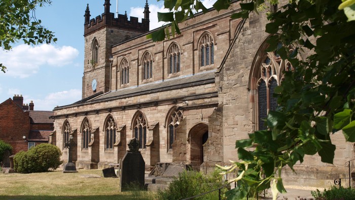 Church with arched windows and a person standing outside.