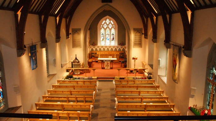 Church interior with wooden pews and stained glass windows