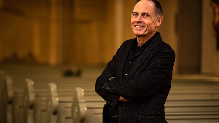 Matthias Nagel vor Kirchenbänken