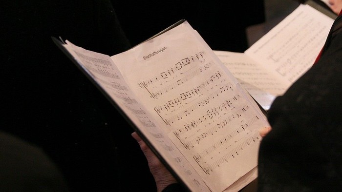En person holder en bladmusikk i hænderne