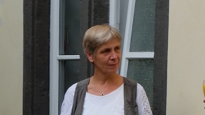 Zwei Frauen stehen vor einem Gebäude und trinken.