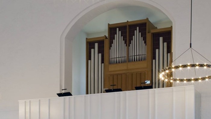 En stor orgel i et lys og moderne rum med kredslyset.