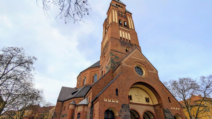 Große Ziegelkirche mit hohem Turm und Rundbogenfenster