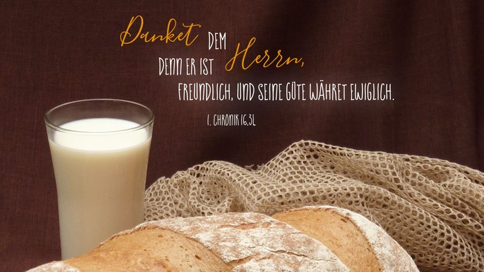Laib Brot und Glas Milch stehen auf Tisch. Spruch: Danket dem Herrn, denn er ist freundlich und seine Güte währet ewiglich. (1. Chronik 16,3L)