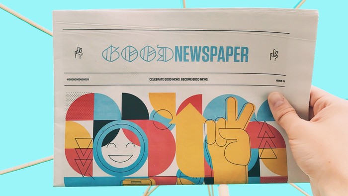 Hand holding colorful newspaper titled