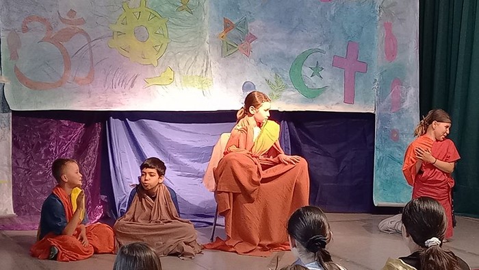 Kinder in religiösen Gewändern, Transparent mit religiösen Symbolen