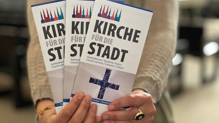 Person hält drei Kirchenführer für die Stadt