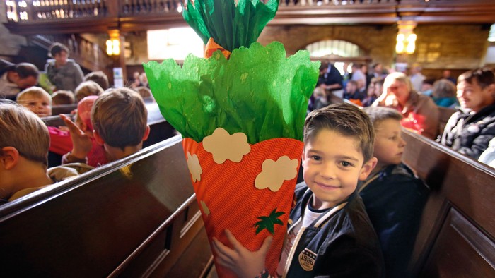 Kind hält große Karotte in Kirche