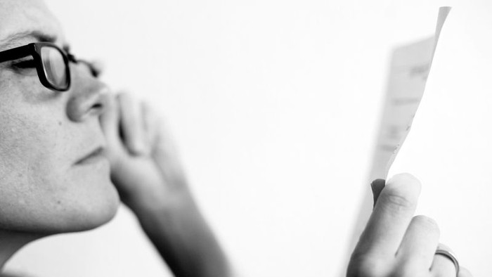 Person mit Brille hält Zahnbürste in der Hand