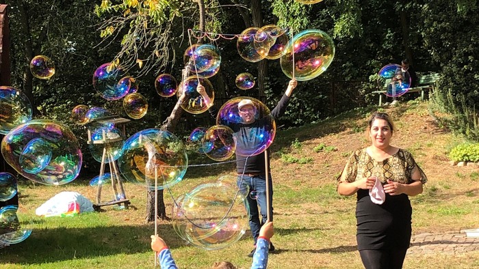 In einem Garten spielen Kinder. Sie machen Seifenblasen.