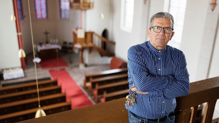 Mann mit Schlüsselbund auf Kirchenempore