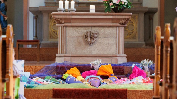 Schultüten liegen vor einem Altar (Motivbild)