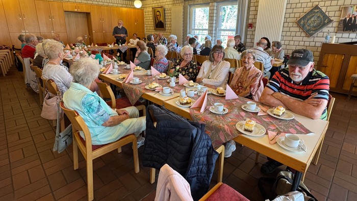 Seniorengruppe beim gemeinsamen Essen in einem gemütlichen Raum