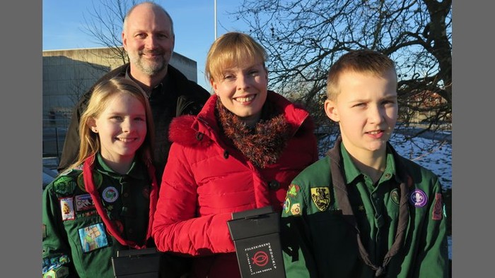En familie af fire poser sammen udendørs