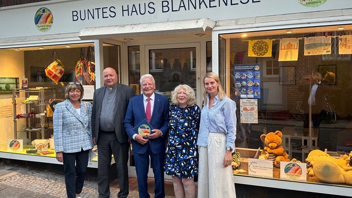 Fünf Personen stehen vor dem Laden