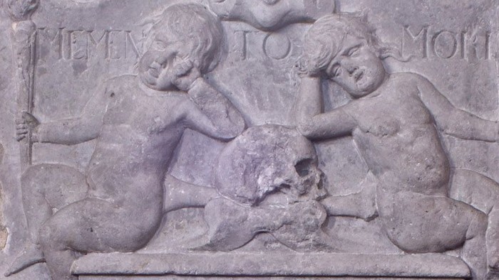 Steinerne Gedenktafel an einer Ziegelmauer mit Relief und Inschrift