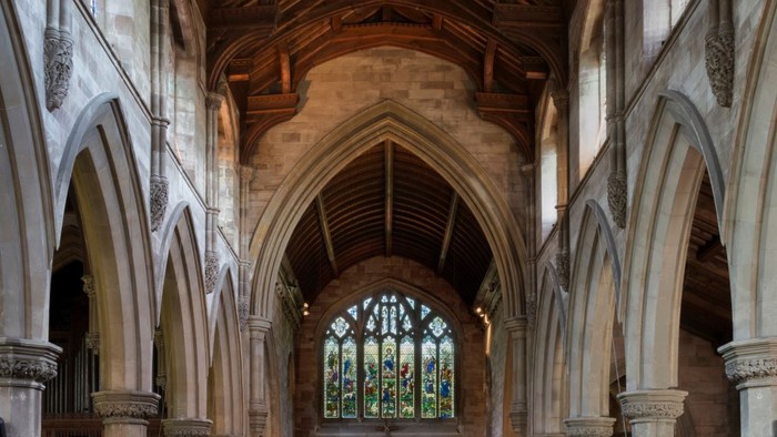 Large, empty church with wooden pews and high ceiling.