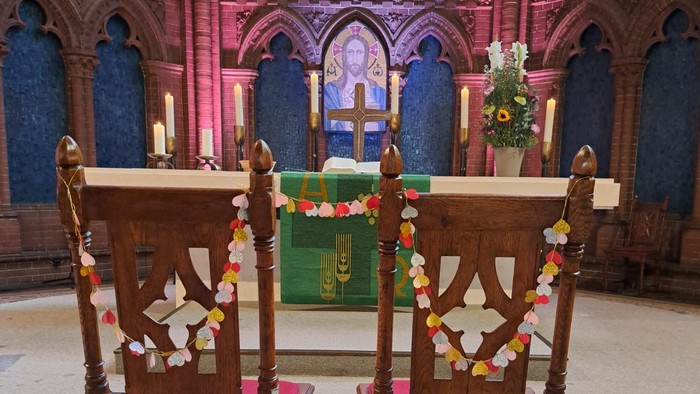 Zwei Stühle mit Girlanden geschmückt stehen vor dem Altar in der Apostel-Paulus-Kirche
