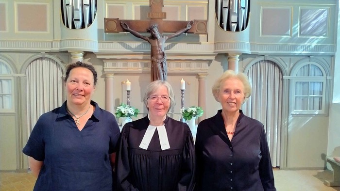 Die neuen KGR-Mitglieder und Pastorin Erichsen stehen vor dem Altar der Kirche in Sieseby.