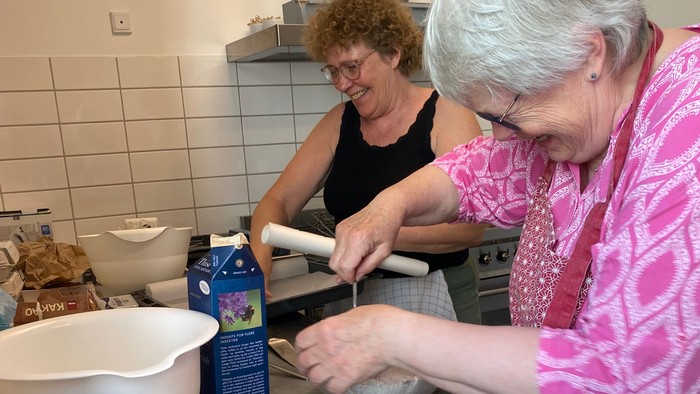 To kvinder laver dej til bagning ved et køkkenbord