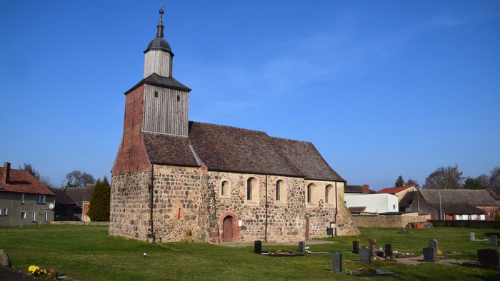 Alte Kirche mit Turm und Friedhof im Sonnenlicht
