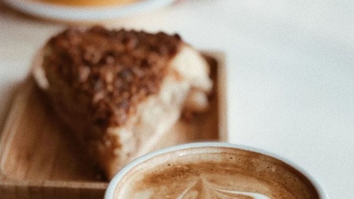 Ein Cappuccino und ein Stück Kuchen auf einem Tisch