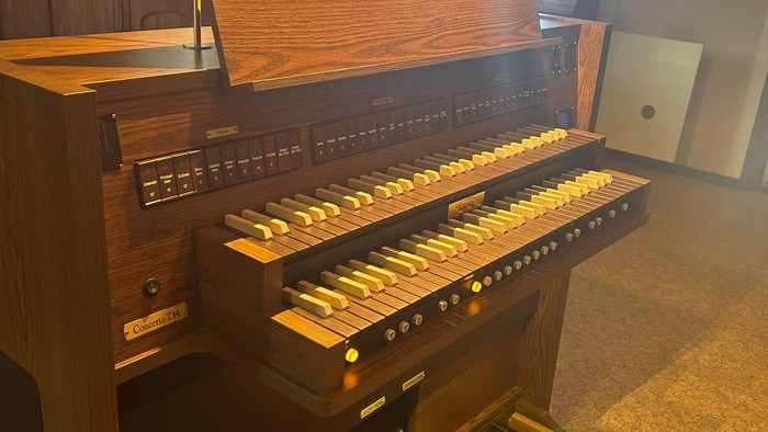 Ein hölzernes Harmonium mit zwei Klaviaturen in einem Raum