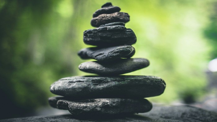 Eine Pyramide aus Kieselsteinen vor grünem Hintergrund