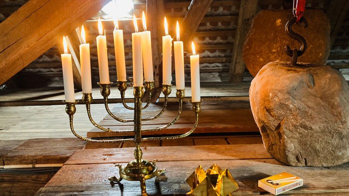 En jødisk menora med lysede lygter på en bord med juledekor.