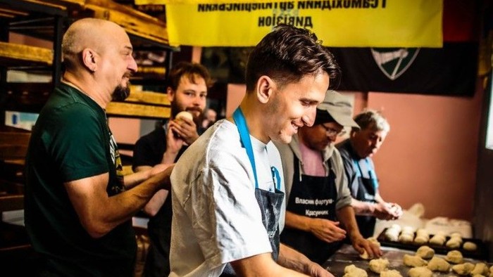 Bäckerei in Charkiw. Drei Männer und zwei Frauen in einer Backstube. Sie backen Brot udn Brötchen.