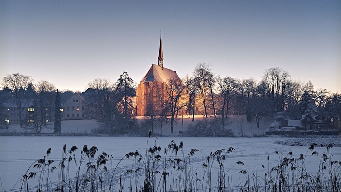 Schneebedeckte Landschaft mit Kirche im Hintergrund