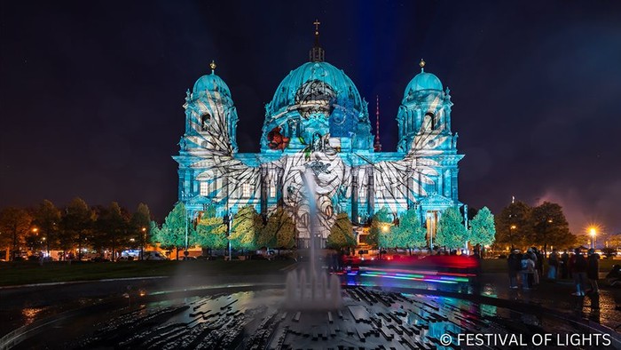 Berliner Dom nachts mit angestrahlter Fassade: Taubenmotiv