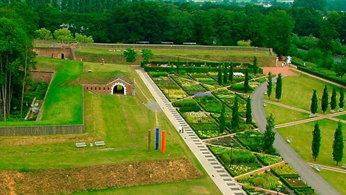 Ein gut gepflegter Garten mit Wegen, Bäumen und Blumenbeeten