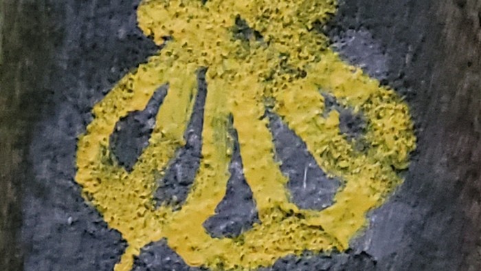 Das Bild zeigt zwei gelbe Symbole auf schwarzem Hintergrund