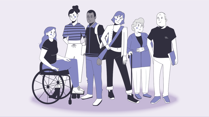 Eine Gruppe von Menschen steht zusammen, eine Person sitzt im Rollstuhl