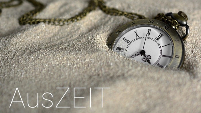 Eine Taschenuhr liegt im Schnee und zeigt die Zeit an.