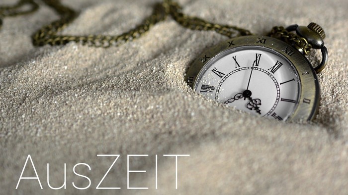 Eine Taschenuhr liegt im Schnee und zeigt die Zeit an.