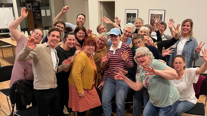 En gruppe af mennesker samlet sig om et piano og poser til en foto