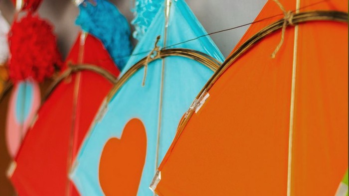 Bunte Drachen hängen an Wand.