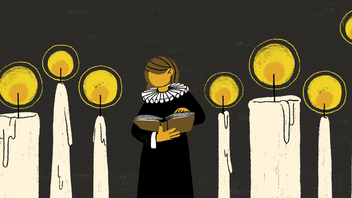 En person med halsbånd læser foran en rekke lysende lysekønge.